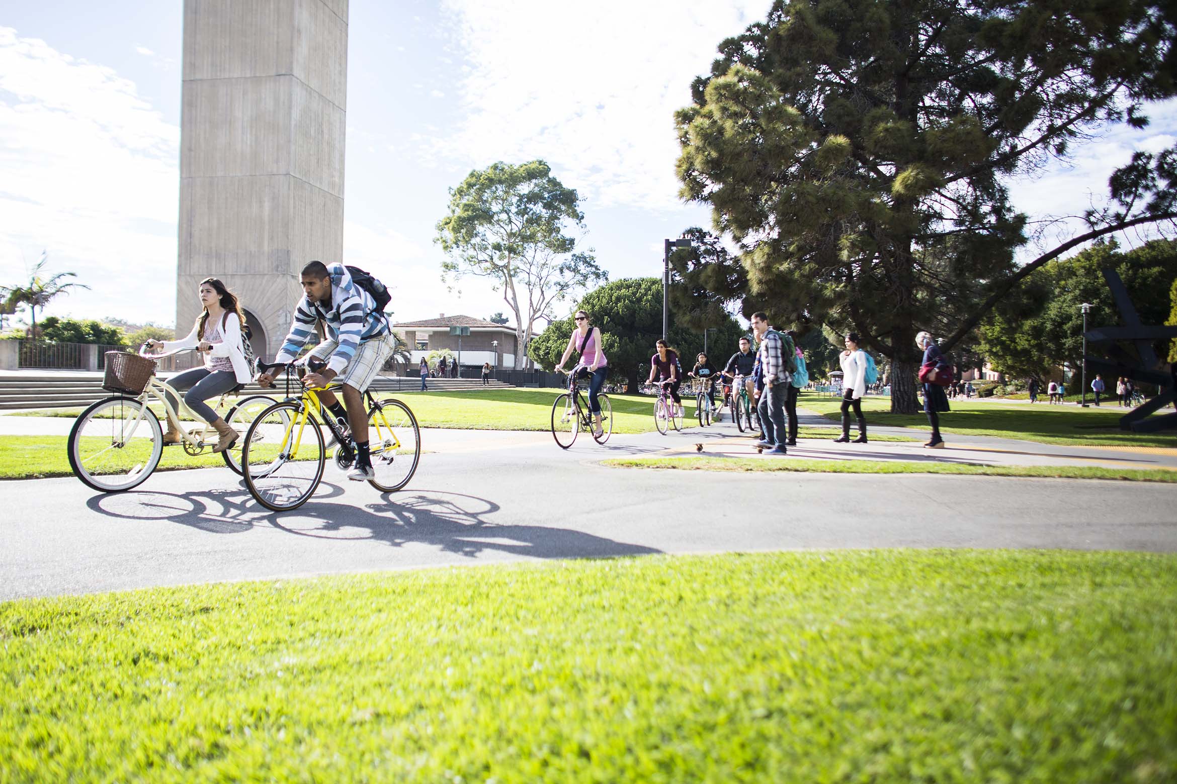Students biking by Storke Tower