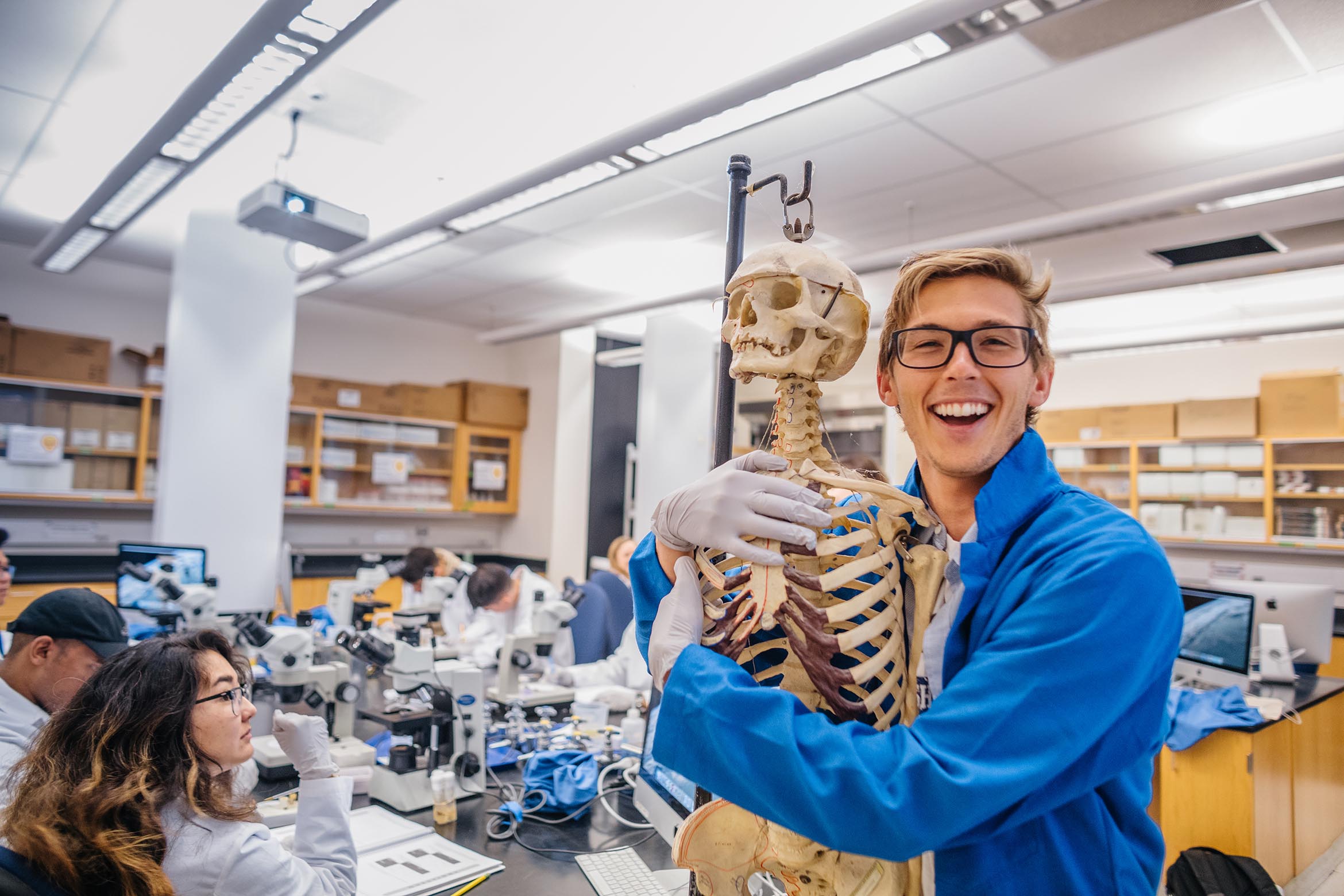 This is a student in a lab coat hugging a skeleton.