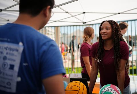 This is a photo of a student manager tabling on sports programming to another student.